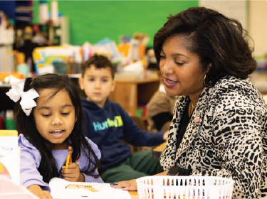 superintendent reading with a young female student